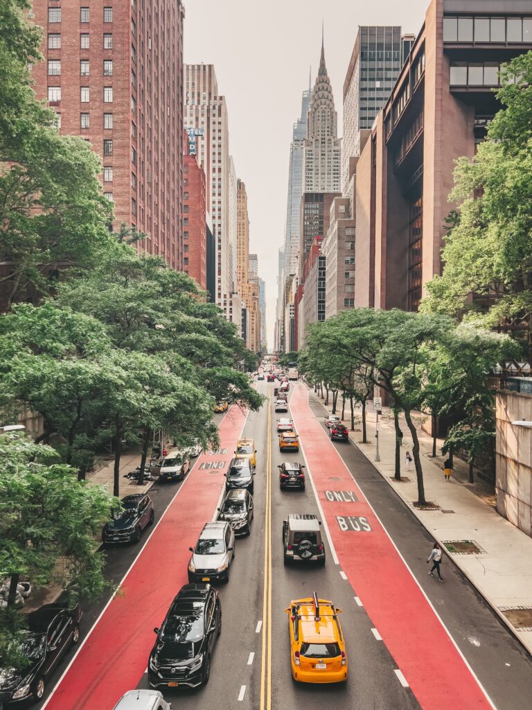 "Chrysler Building e taxi giallo lungo una strada di Manhattan"